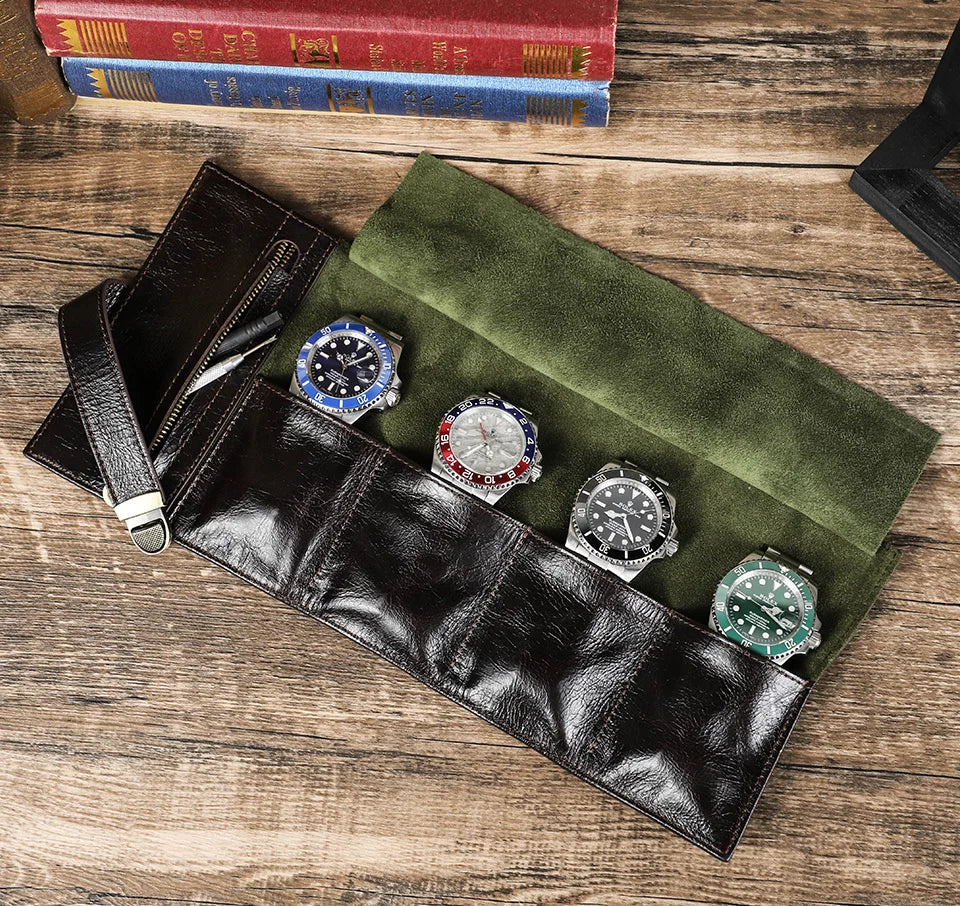 Vintage brown leather watch roll travel case, open to display four individual suede-lined slots and an accessory pocket.